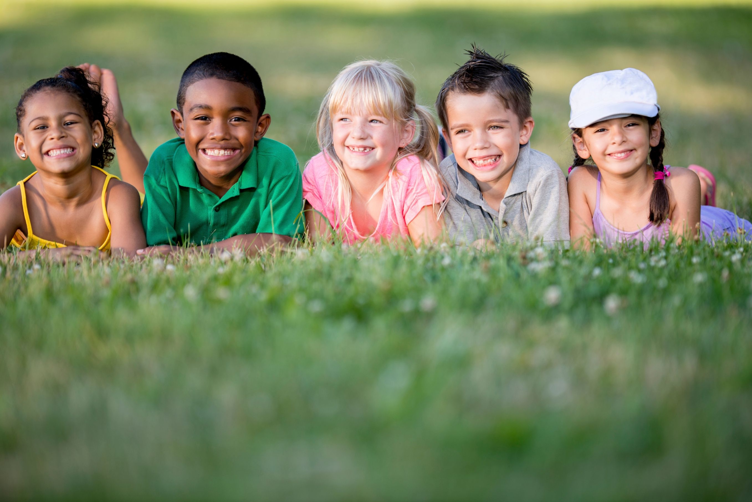 Kinder liegen auf dem Rasen